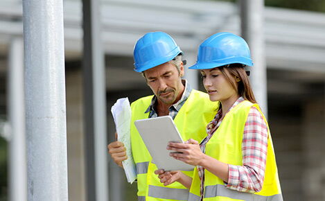 Frau und Man auf einer Baustelle im Gespräch